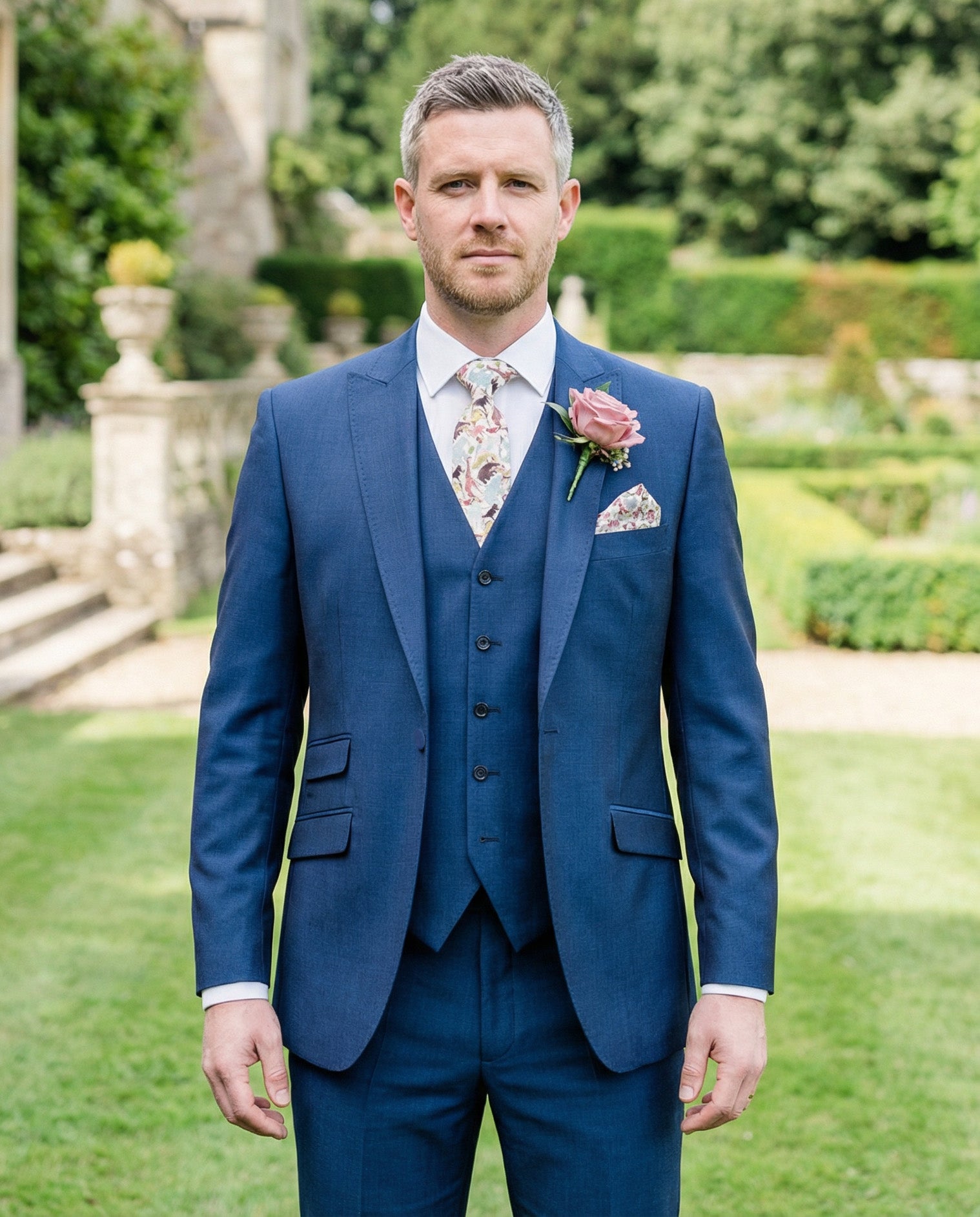 Groom in a royal blue lounge hire suit with a floral tie made with Liberty of London fabric.