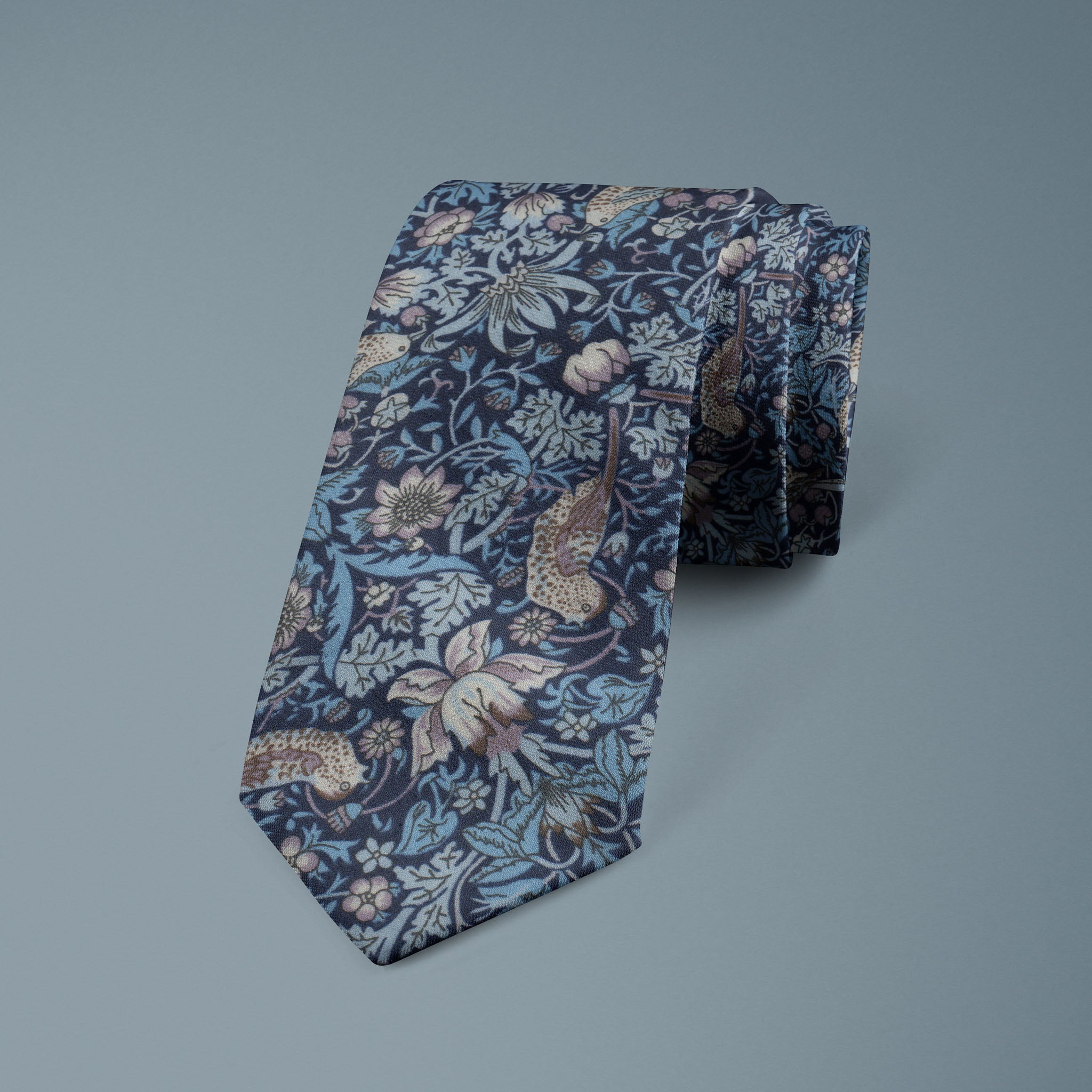 Liberty Tie featuring the Strawberry Thief design in fine Tana Lawn cotton, with intricate birds, berries and trailing foliage in rich reds, greens, blues and warm tones on a deep coloured ground, ideal for Weddings, formal events and Grooms, available to buy from Black Tie Menswear.